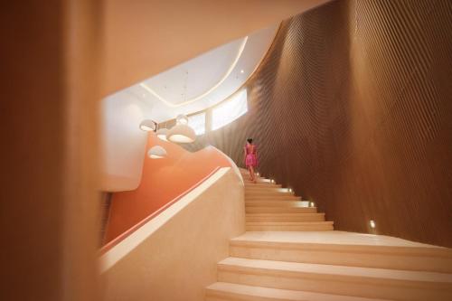 a person walking down the stairs in a building at Mandala Cham Bay Hotel Mũi Né in Mui Ne