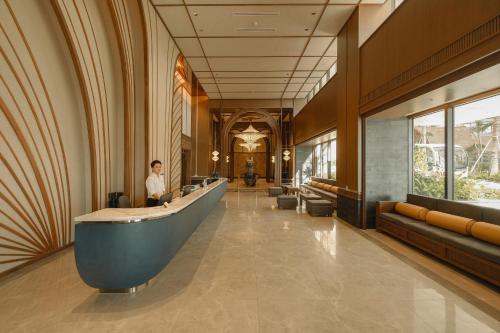 a woman standing in the lobby of a hotel at Mandala Cham Bay Hotel Mũi Né in Mui Ne