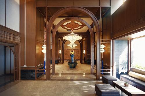 a hallway of a building with a large chandelier at Mandala Cham Bay Hotel Mũi Né in Mui Ne