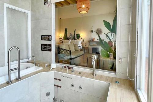 a bathroom with a tub and a large mirror at 阿爾法民宿AlphaVilla in Hengchun