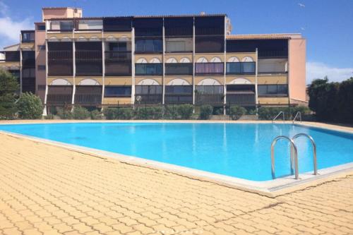une piscine vide en face d'un bâtiment dans l'établissement Naturiste Cap d'Agde Port Vénus 7, au Cap d'Agde