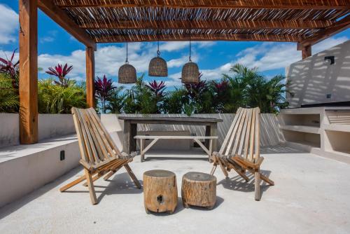 two chairs and a picnic table on a patio at Bright 2BR Loft with Rooftop Pool in Best Tulum Downtown Location in Tulum