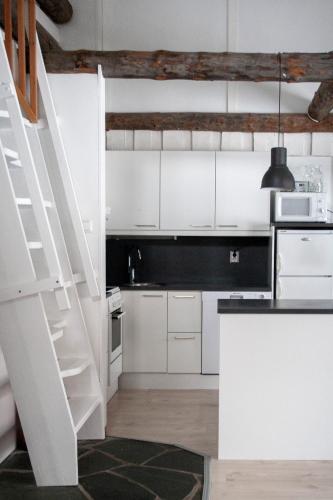 a white kitchen with white cabinets and a staircase at Vuokatinportintie in Vuokatti