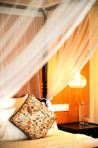a bedroom with a bed with a pillow on it at The Sun House in Galle
