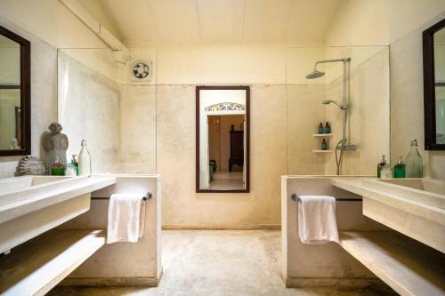 a bathroom with two sinks and a mirror at The Sun House in Galle