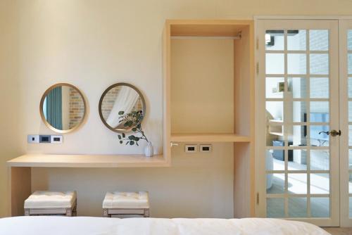 a bedroom with two mirrors and a bed at 阿爾法民宿AlphaVilla in Hengchun
