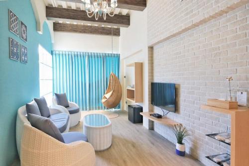 a living room with a couch and a tv at 阿爾法民宿AlphaVilla in Hengchun