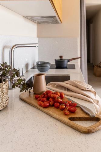 a cutting board with tomatoes on top of a kitchen counter at Fari Stone Villas in Skala Marion