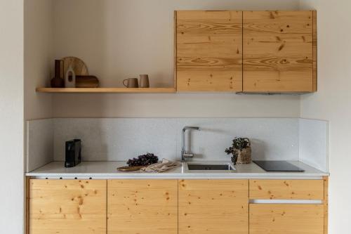 a kitchen with wooden cabinets and a sink at Fari Stone Villas in Skala Marion