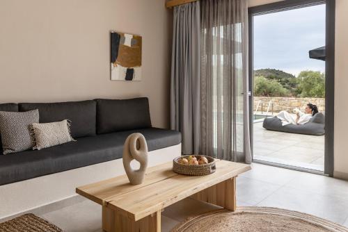 a living room with a couch and a table at Fari Stone Villas in Skala Marion