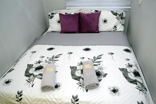 a bed with two pillows and two towels on it at Lidija Apartman in Bitola