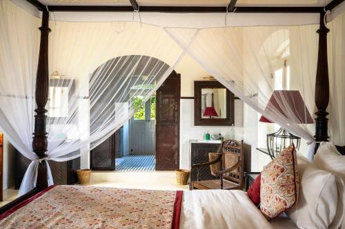 a bedroom with a bed with a canopy at The Sun House in Galle