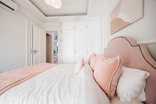 a white bedroom with a large bed with pillows at Soleil Residence Westlake Hanoi in Hanoi