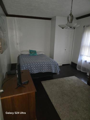 LorainにあるLeisure guest homeのベッドルーム1室(ベッド1台、ドレッサー、テレビ付)