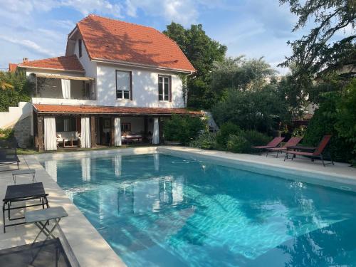 une maison avec une piscine devant une maison dans l'établissement Au Cœur de Vaison la Romaine Maison de charme, jardin, piscine., à Vaison-la-Romaine