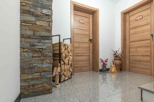 a hallway with two wooden doors and a stone wall at Goralove Pole in Brzegi