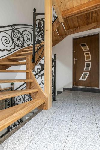 a wooden staircase with a metal railing next to a door at Goralove Pole in Brzegi
