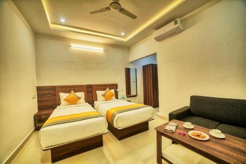 a hotel room with two beds and a couch at HOTEL VISA INN NEAR KEMPEGOWDA AIRPORT in Bengaluru