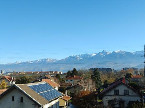une ville avec un groupe de maisons avec des montagnes enneigées dans l'établissement Spacieux T4 vue sur les Alpes, à Seyssinet-Pariset