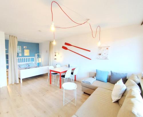 a living room with a couch and a table at MOOKI Beach Apartment in Bodensdorf