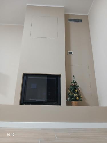 a christmas tree in a living room with a tv at La Casa nella Contea in Terni