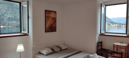 a bedroom with two windows and a bed in it at Villa Kamena in Kotor
