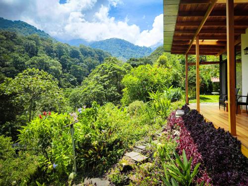 a house with a balcony with a view of the mountains at Cloudbridge Nature Reserve in Herradura