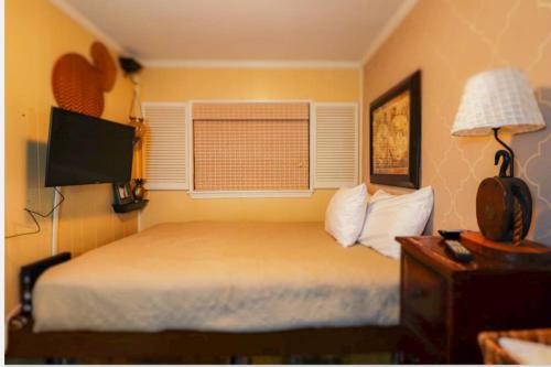 a bedroom with a bed with a television and a window at Seascape Retreat in Tybee Island