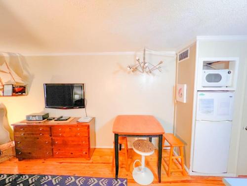 a living room with a table and a refrigerator at Seascape Retreat in Tybee Island