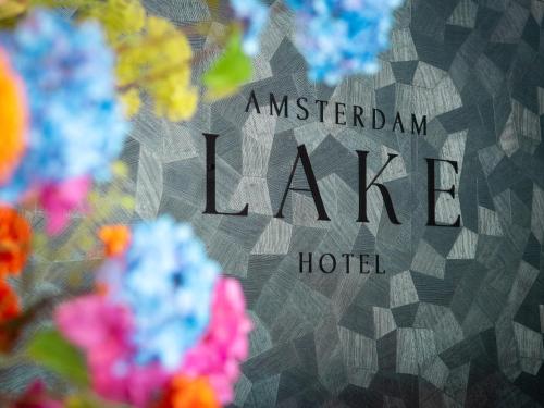 a sign for an american lake hotel with flowers at Amsterdam Lake Hotel in Badhoevedorp