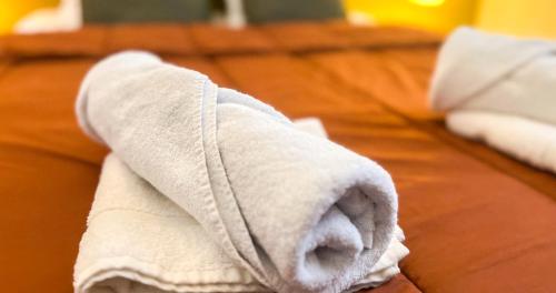 un rouleau de serviettes blanches posé sur un lit dans l'établissement WIFI - HyperCenter - In the heart of Avignon!, à Avignon