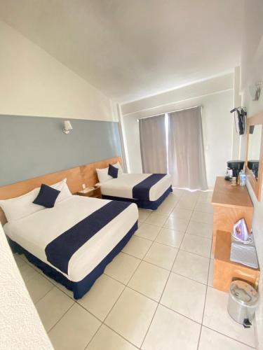 a hotel room with two beds and a window at AM Amakal Hotel & Park in Santa Cruz Huatulco