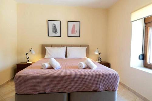 une chambre avec un lit avec deux serviettes dessus dans l'établissement Siena Cottage, à Nea Makri