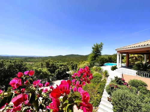 a garden with pink flowers and a house at Villa Azur climatisée pour 6 personnes avec piscine et belle vue mer à La Londe les Maures in La Londe-les-Maures