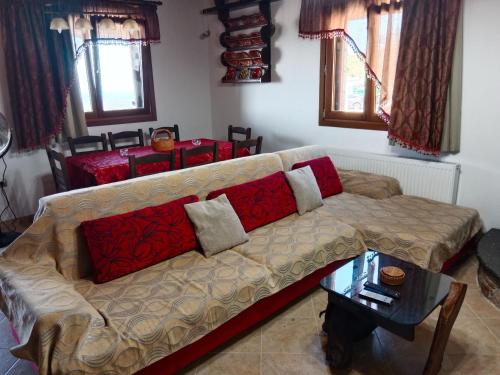 a living room with a couch with pillows on it at Tsampika's Traditional Stone Cottage in Siana in Siána