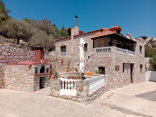 a stone building with a fountain in front of it at Tsampika's Traditional Stone Cottage in Siana in Siána