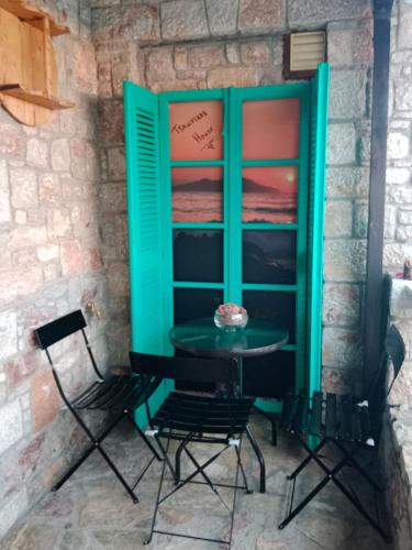 a table and chairs in front of a wall at Tsampika's Traditional Stone Cottage in Siana in Siána