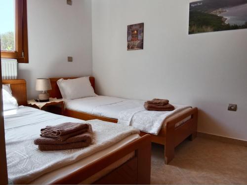 two beds in a room with towels on them at Tsampika's Traditional Stone Cottage in Siana in Siána