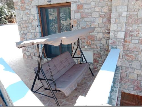 a table and a couch in front of a building at Tsampika's Traditional Stone Cottage in Siana in Siána
