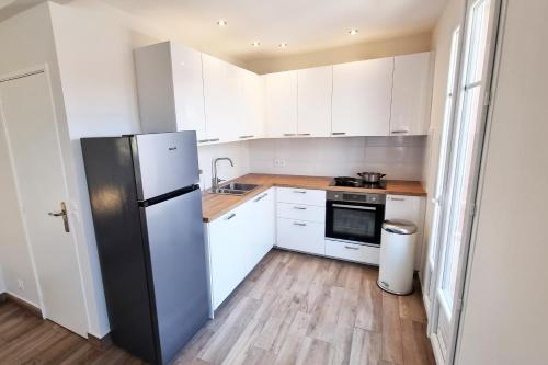  La cuisine est équipée de placards blancs et d'un réfrigérateur. dans l'établissement 