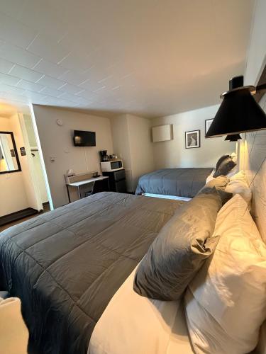 a hotel room with two beds and a lamp at New Country Motel in Swan River
