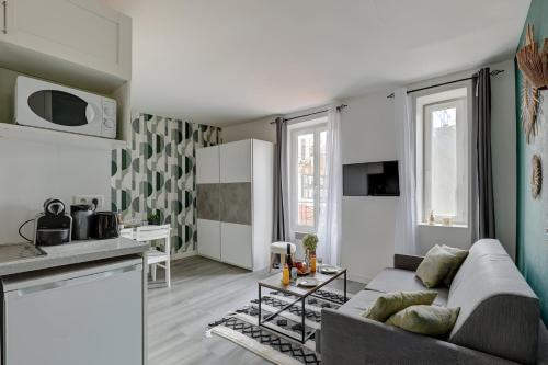 un salon avec un canapé et une cuisine dans l'établissement Bluestay 203 - Charming Studio, à Bagnolet