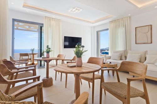 a living room with tables and chairs and a couch at Alsalos villas in Amoopi