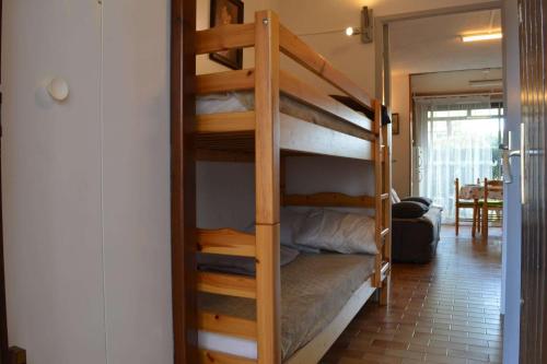 Ce lit superposé se trouve dans un dortoir avec une échelle. dans l'établissement Appartement Studio cabine 4 couchages ARGELES SUR MER AR030-036, à Argelès-sur-Mer