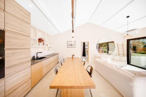 une cuisine et une salle à manger avec une table et des chaises en bois dans l'établissement 3min de la mer - 14P - Calme - Moderne - Jacuzzi - BBQ, à Hyères