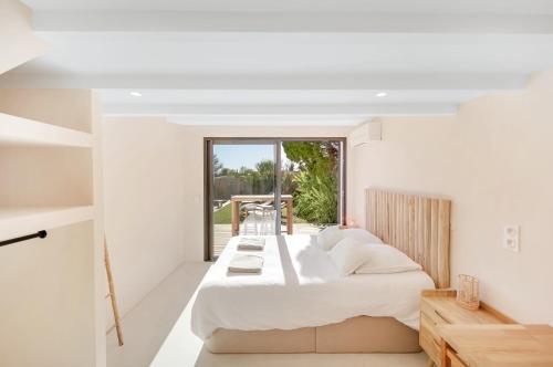 une chambre avec un grand lit et une fenêtre dans l'établissement 3min de la mer - 14P - Calme - Moderne - Jacuzzi - BBQ, à Hyères