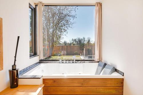 Cette chambre dispose d'une grande fenêtre et d'une baignoire. dans l'établissement 3min de la mer - 14P - Calme - Moderne - Jacuzzi - BBQ, à Hyères