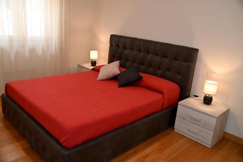 una camera da letto con un letto grande con un copriletto rosso di Casetta via delle Cave a Roma
