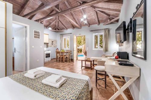 a bedroom with a bed and a desk and a kitchen at Villa Palataki II in Kardamili