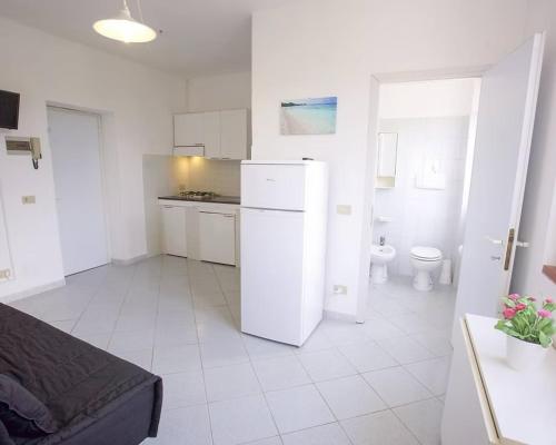 a white kitchen with a refrigerator and a toilet at Villa Conti Residence in Lacona